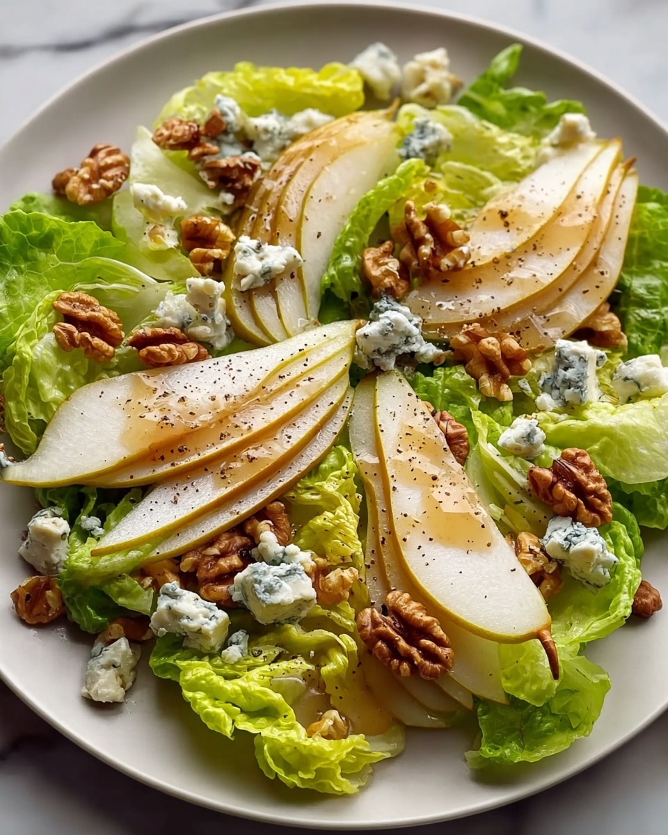 The dish is a fresh salad served on a white plate, placed on a white marbled surface. The base layer consists of bright green leafy lettuce spread evenly across the plate. On top, there are several slices of pear, each cut into thin wedges showing a light yellow outer skin and white inner flesh. Scattered between the pear slices are small chunks of blue cheese, with a creamy white texture and blue veins. Crunchy brown walnut halves are spread throughout the salad, adding texture. The entire salad is drizzled with a glossy layer of honey, visible as a light golden sheen, and sprinkled with coarse black pepper for contrast. photo taken with an iphone --ar 4:5 --v 7