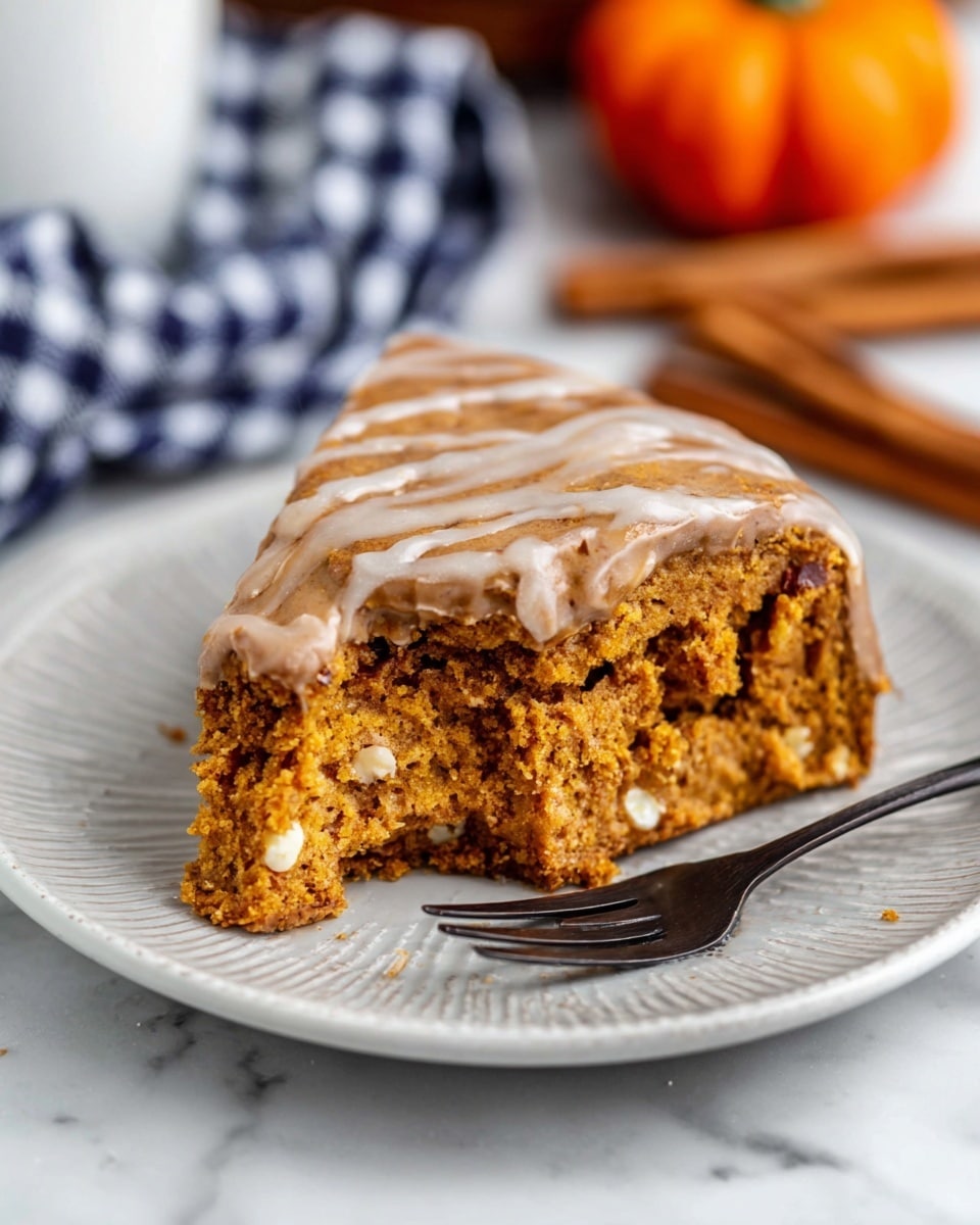 A close-up view of a pie with three visible layers: a light golden, flaky crust at the base and edges, a thick middle layer of crumbly brown cookie dough mixed with white chocolate chunks, and a final top layer of light brown chocolate drizzle applied in a crisscross pattern over the pie's surface. The pie is in a clear glass pie dish, placed on a white marbled surface. In the background, there are small bright orange candy pumpkins and a white pot holder with black writing partially visible. Photo taken with an iphone --ar 4:5 --v 7