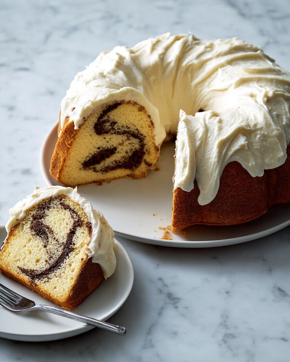 A round bundt cake sits on a white plate with a white marbled background, covered in thick, creamy white frosting that looks soft and swirled. One slice is cut out, showing two layers of light golden cake with a dark brown swirl running through the middle, giving a marbled effect. The inside texture looks moist and crumbly. The cut slice is placed on a small white plate next to the cake with a silver fork beside it. Photo taken with an iphone --ar 4:5 --v 7